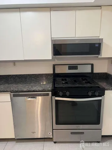 a stove top oven sitting inside of a kitchen