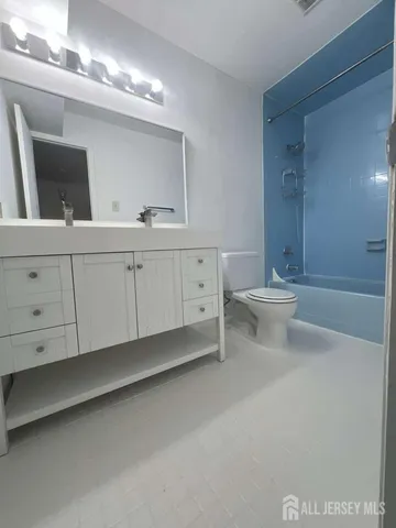 a spacious bathroom with a double vanity sink a toilet and a mirror