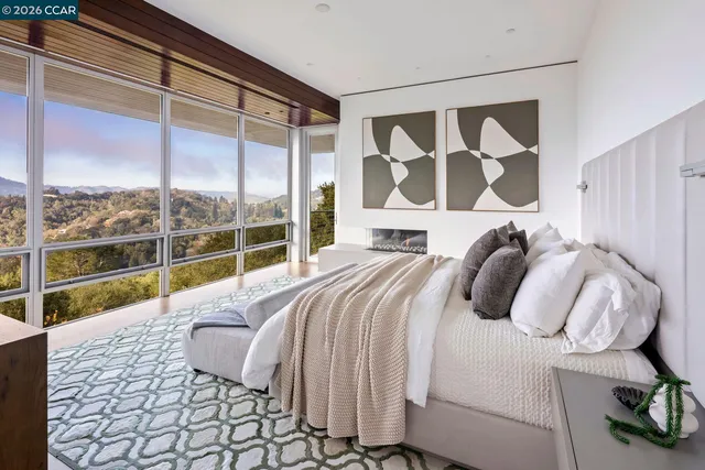 a bed sitting in a bedroom next to a large window with potted plants