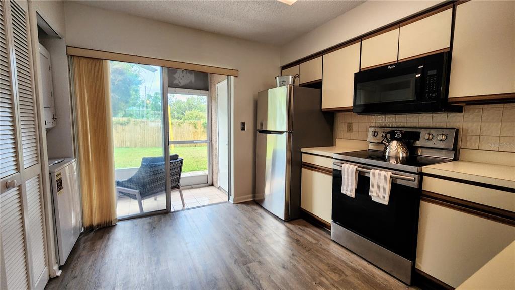 6440 Spring Flower Drive, Unit 14 New Port Richey, FL 34653 - Photo 11 of 35 a kitchen with stainless steel appliances granite countertop a refrigerator stove top oven and sink