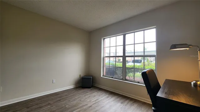 a view of a workspace with furniture and a window