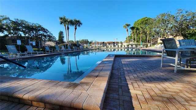 a view of a swimming pool with a patio and garden