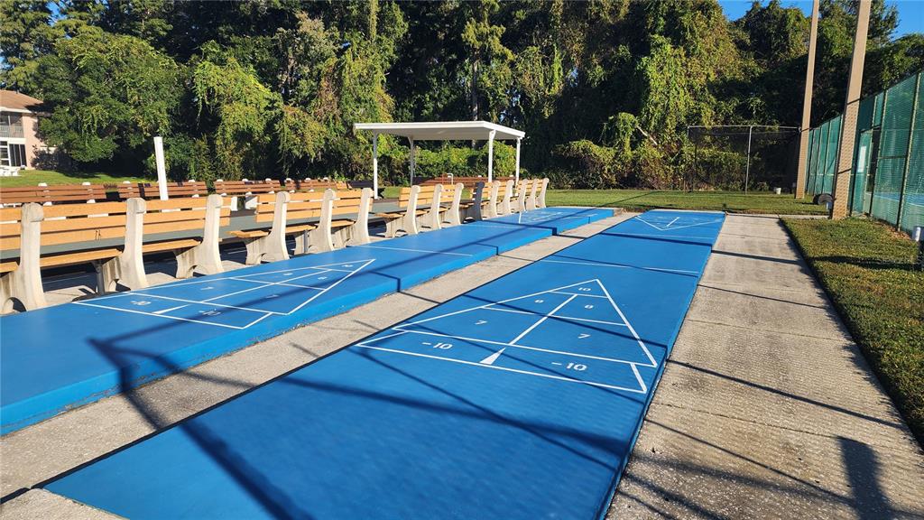 6440 Spring Flower Drive, Unit 14 New Port Richey, FL 34653 - Photo 29 of 35 a view of a patio with table and chairs a barbeque with wooden floor and fence