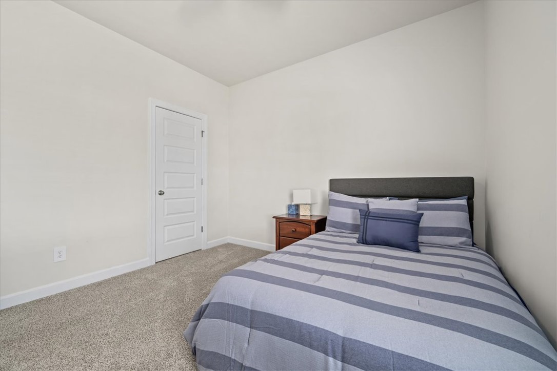 106 Purcell Way Easley, SC 29642 - Photo 34 of 39 This cozy bedroom features plush carpeting and a classic paneled door, offering a comfortable and inviting retreat.