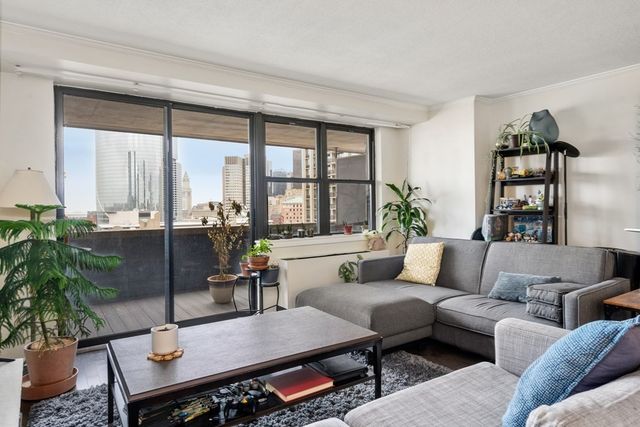 a living room with furniture potted plant and a large window