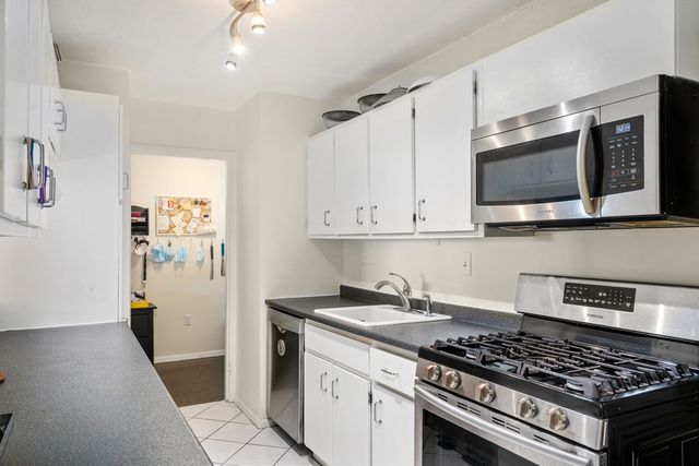 a kitchen with stainless steel appliances granite countertop a stove and a microwave