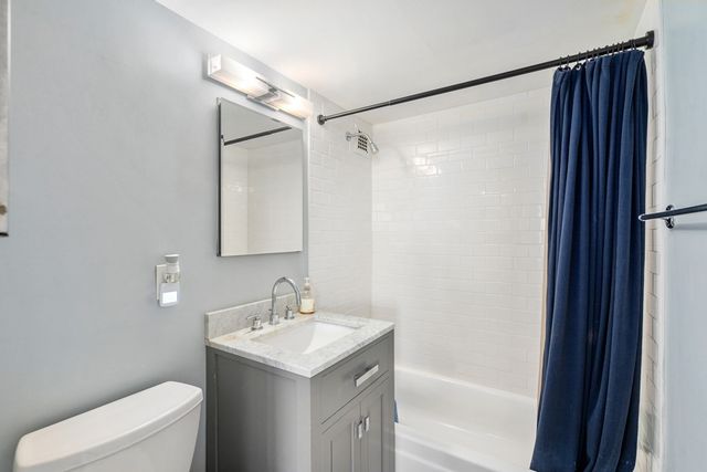 a bathroom with a sink mirror toilet and shower