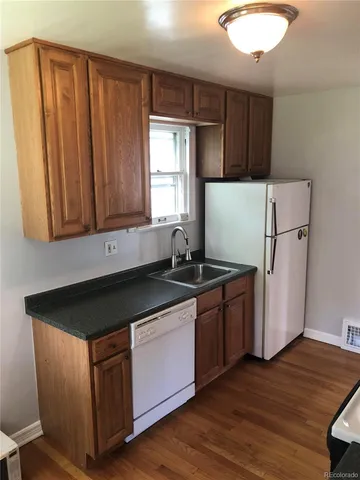 a kitchen with granite countertop wooden cabinets and a stove top oven
