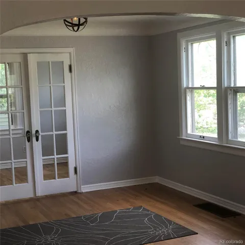 an empty room with wooden floor and windows