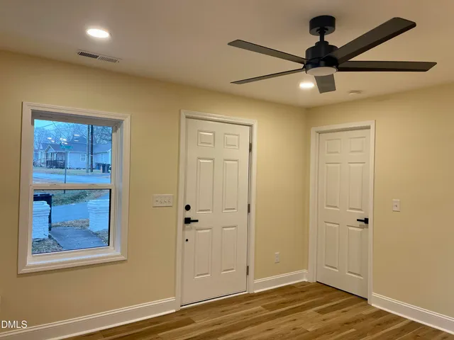 a view of empty room with wooden floor