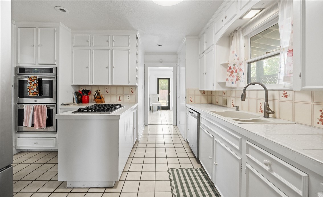 245 Leming Avenue Corpus Christi, TX 78404 - Photo 9 of 33 a kitchen with kitchen island a counter top space a sink stainless steel appliances and cabinets