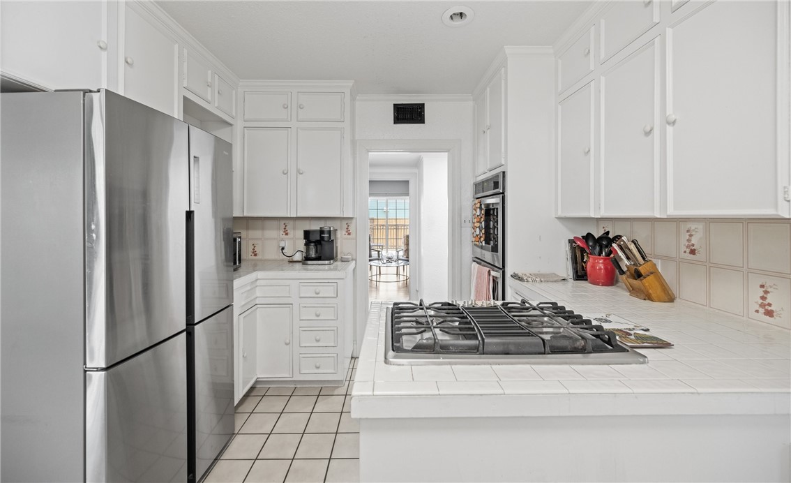 245 Leming Avenue Corpus Christi, TX 78404 - Photo 10 of 33 a kitchen with stainless steel appliances granite countertop a refrigerator stove and white cabinets