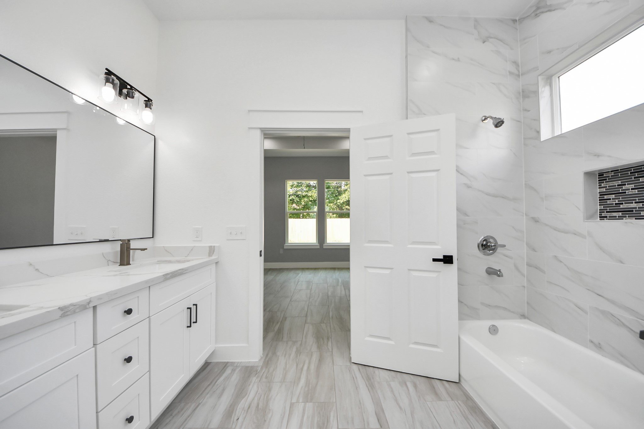 406 South Iowa Street La Porte, TX 77571 - Photo 30 of 49 a bathroom with a granite countertop sink a large mirror a bathtub and next to a window