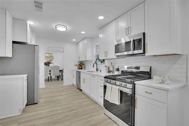 a kitchen with stainless steel appliances a stove microwave and cabinets