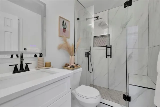 a bathroom with a sink a toilet and a shower