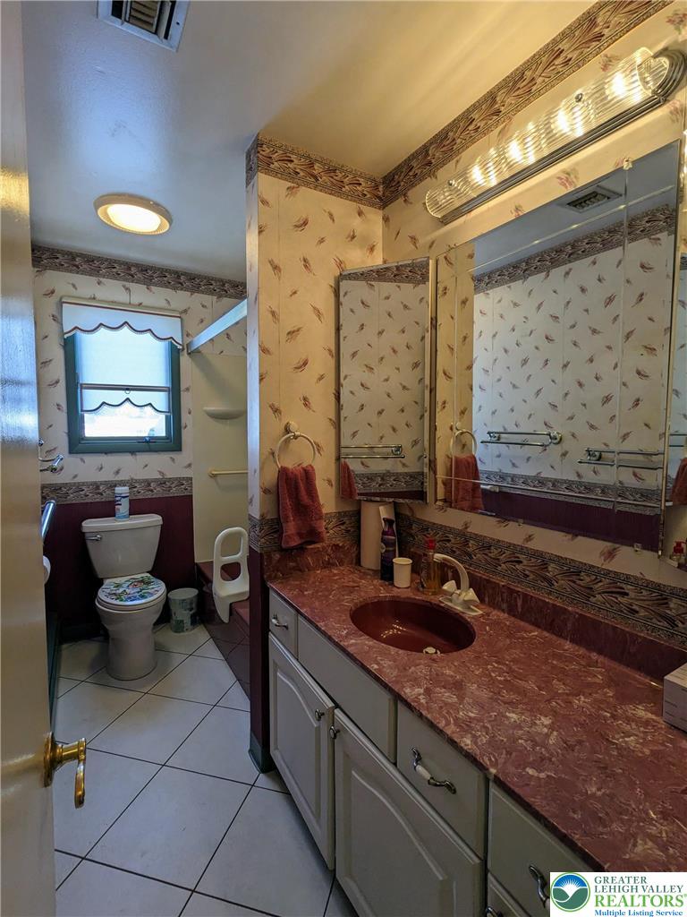 107 South 10th Street Coplay, PA 18037 - Photo 35 of 43 a bathroom with a granite countertop sink a toilet and mirror
