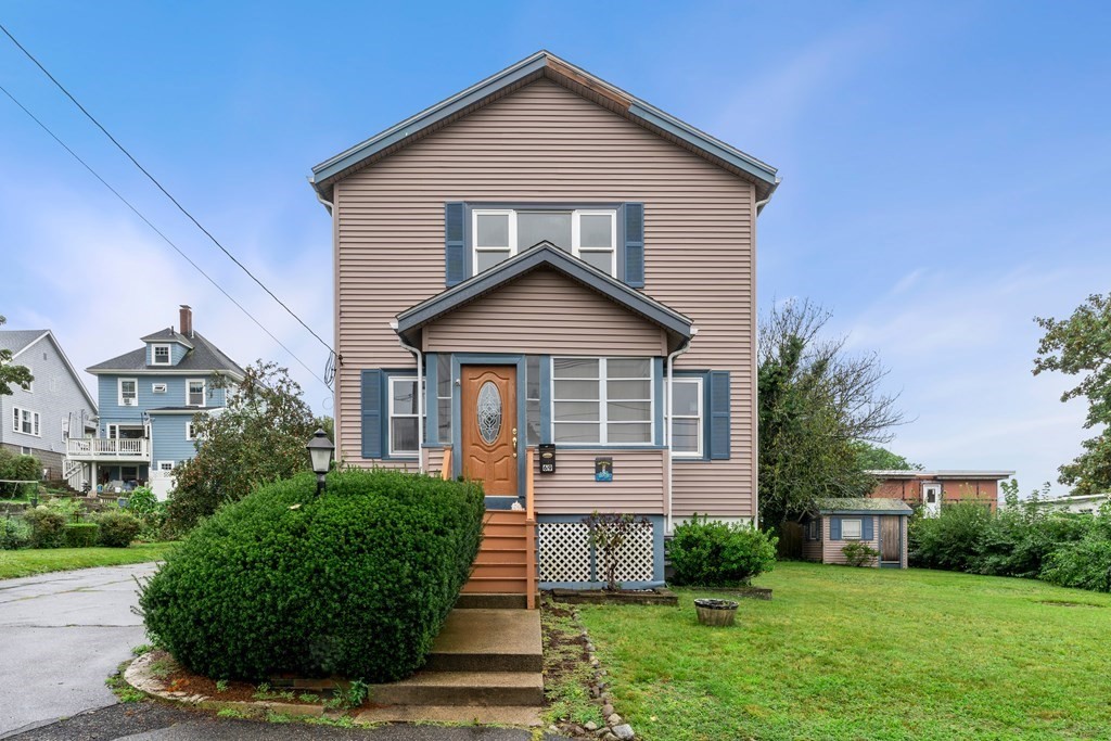 69 Fox Hill Road Nahant, MA 01908 - Photo 2 of 42 a front view of a house with a yard and garage