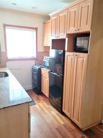 a kitchen with stainless steel appliances granite countertop a refrigerator a stove a sink and a microwave