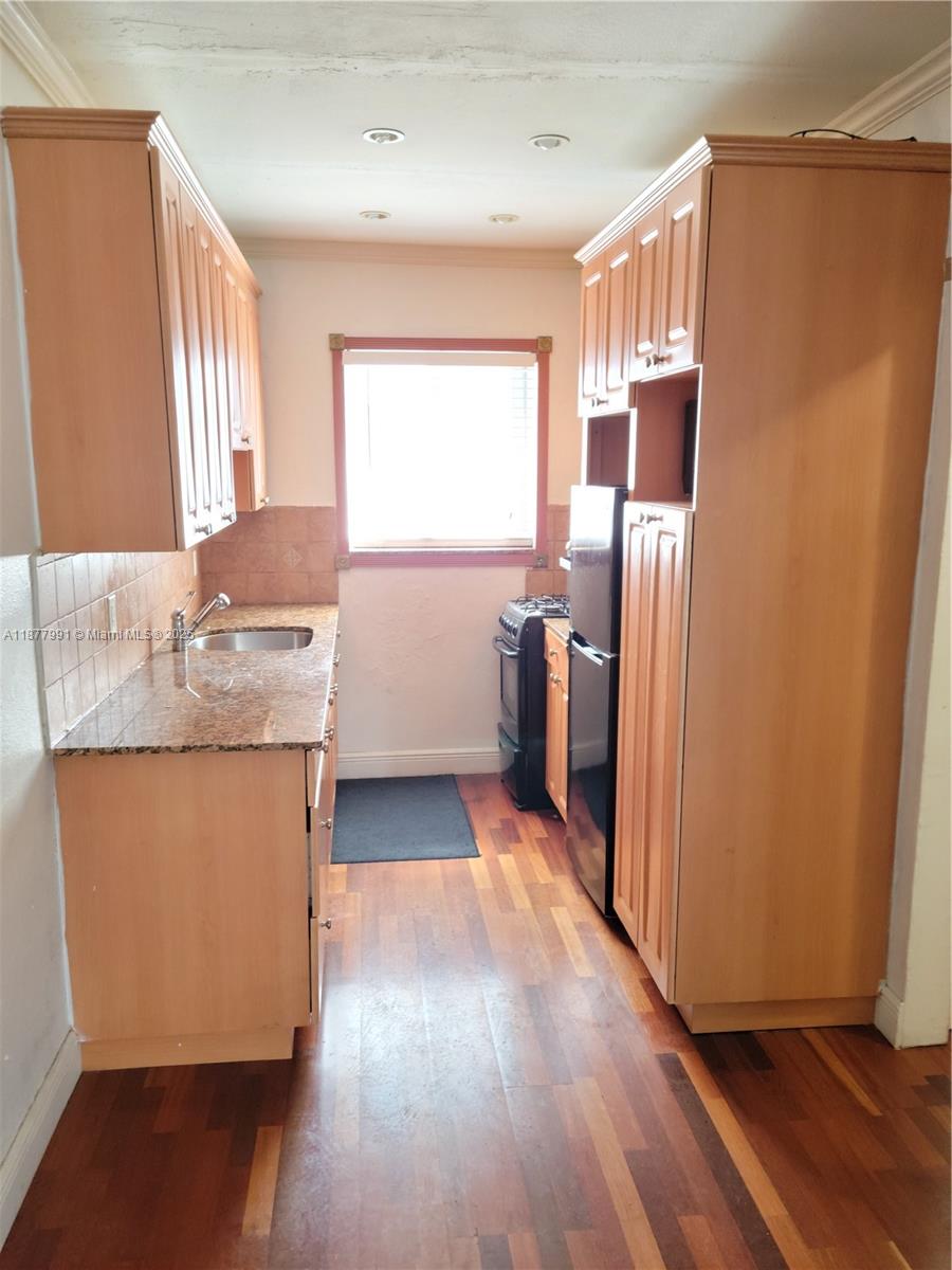 7315 Byron Avenue, Unit 17 Miami Beach, FL 33141 - Photo 5 of 10 a kitchen with stainless steel appliances granite countertop a refrigerator a sink and dishwasher