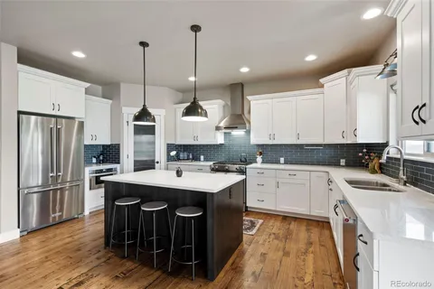 a kitchen with a sink a center island cabinets and stainless steel appliances