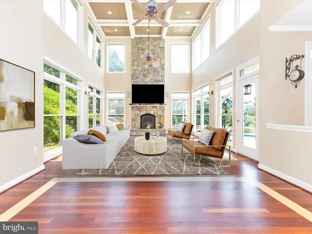 a view of a living room with furniture flat screen tv and floor to ceiling window