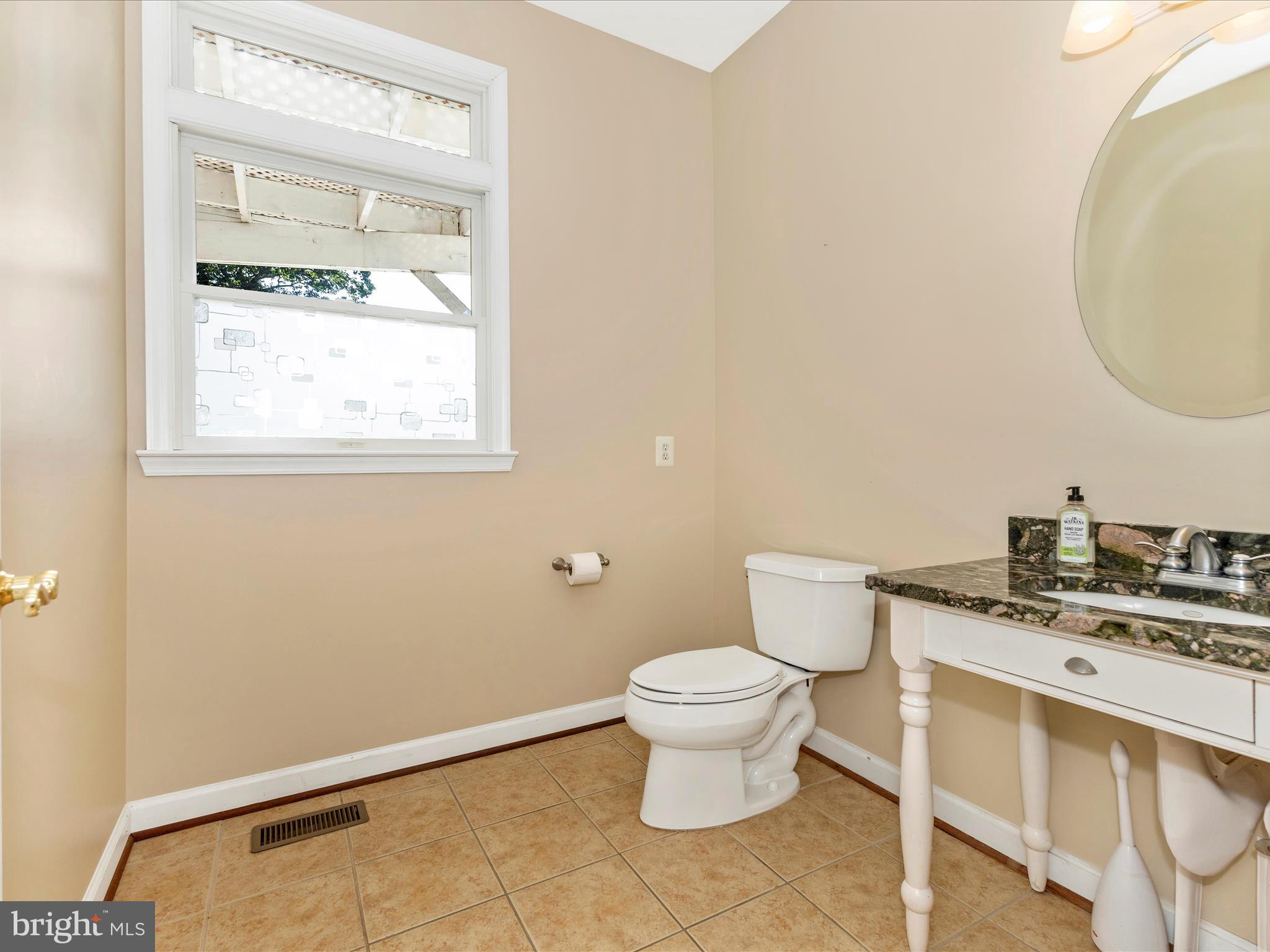2305 Mt Ephraim Road Adamstown, MD 21710 - Photo 29 of 87 a bathroom with a granite countertop toilet a sink and a mirror