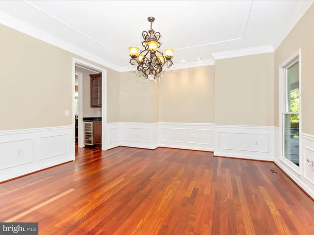 a open kitchen with stainless steel appliances granite countertop a stove top oven a dining table and chairs with wooden floor