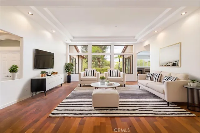 a living room with a couch a flat screen tv and a large window