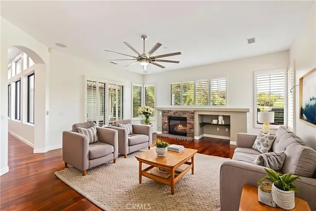 a living room with furniture fireplace and a large window