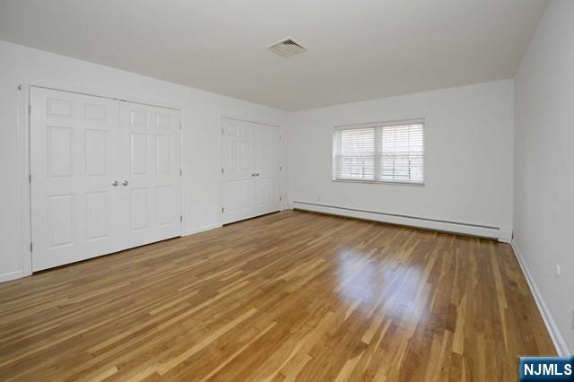 20-30 Ridge Road, Unit A5 Ridgewood, NJ 07450 - Photo 15 of 26 an empty room with wooden floor and windows