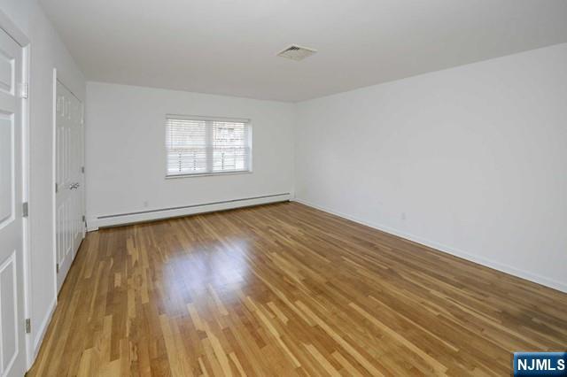 20-30 Ridge Road, Unit A5 Ridgewood, NJ 07450 - Photo 16 of 26 an empty room with wooden floor and windows