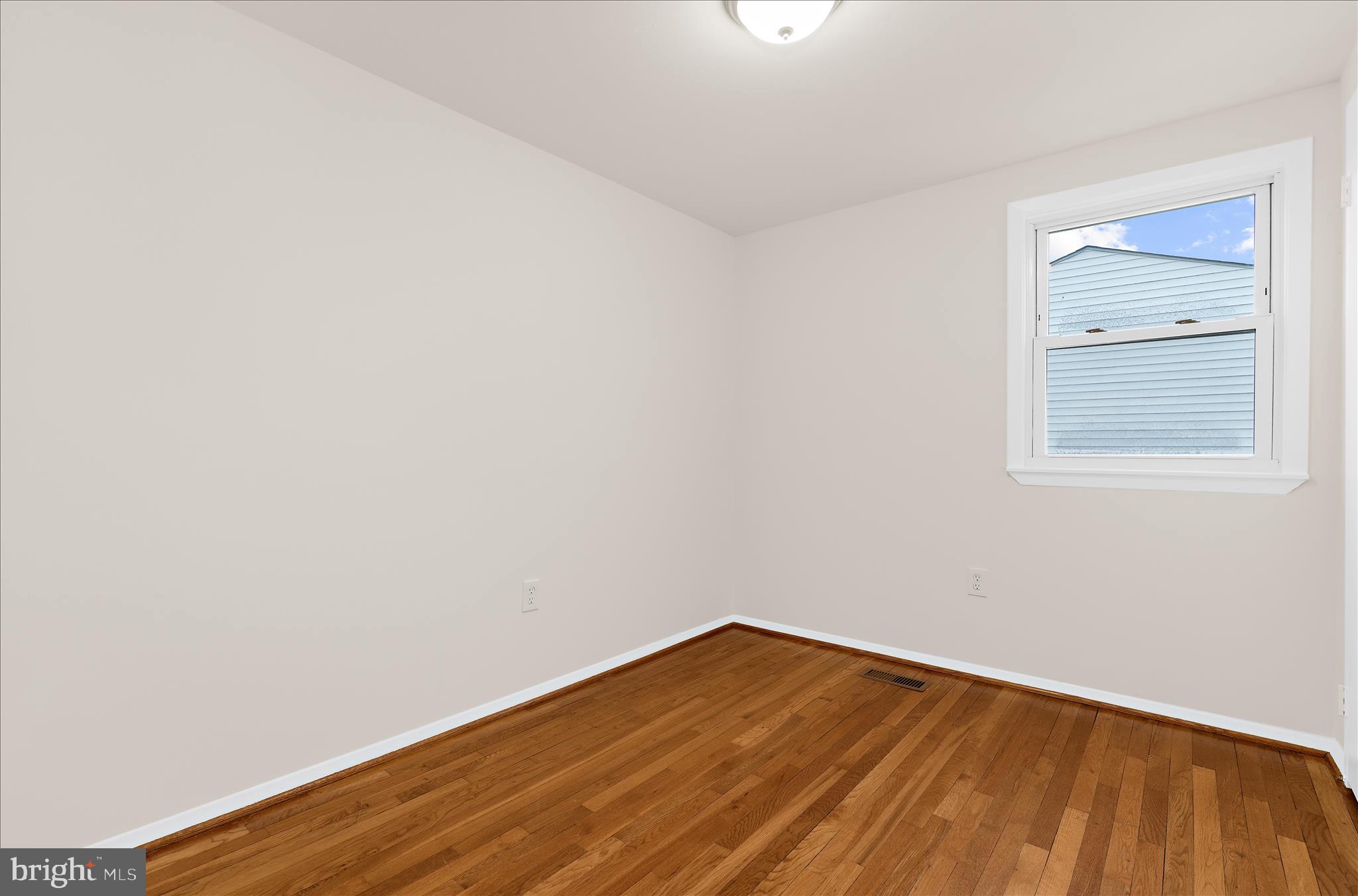 725 Kingston Road Baltimore, MD 21220 - Photo 23 of 55 a view of an empty room with wooden floor and a window