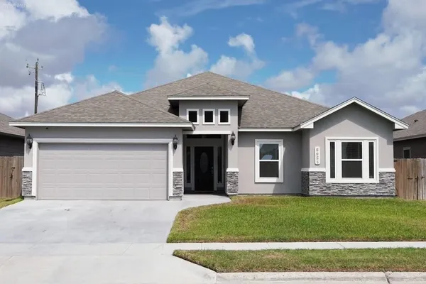 a front view of a house with a garden and yard