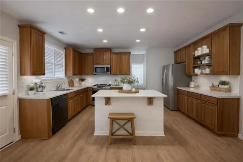 a kitchen with a sink cabinets and wooden floor