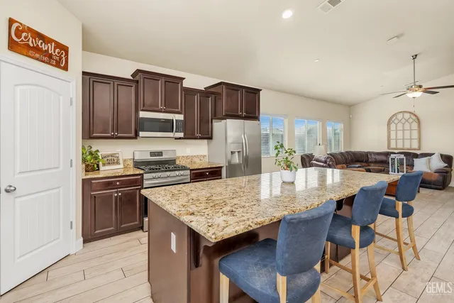 a kitchen with granite countertop a stove refrigerator and cabinets