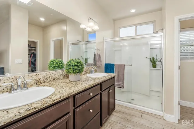 a bathroom with a granite countertop sink shower and a mirror