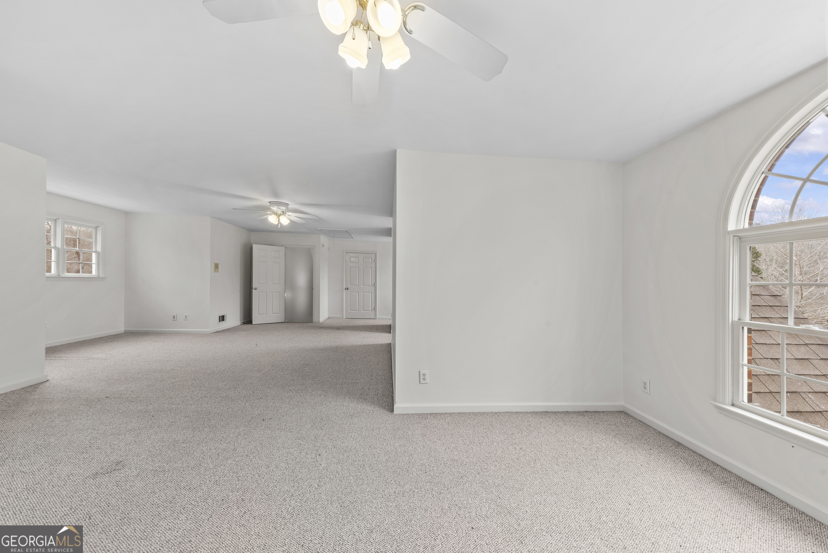 1171 River Run Bishop, GA 30621 - Photo 65 of 78 an empty room with a chandelier fan and windows