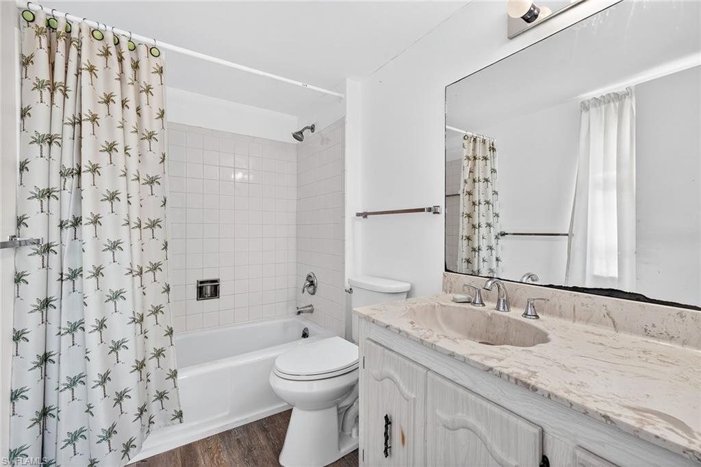 200 Pebble Beach Boulevard, Unit D406 Naples, FL 34113 - Photo 13 of 24 a bathroom with a granite countertop sink a toilet and shower