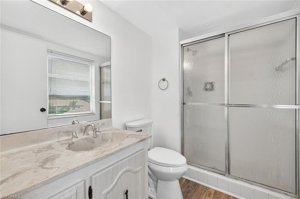 200 Pebble Beach Boulevard, Unit D406 Naples, FL 34113 - Photo 17 of 24 a bathroom with a granite countertop sink toilet and shower