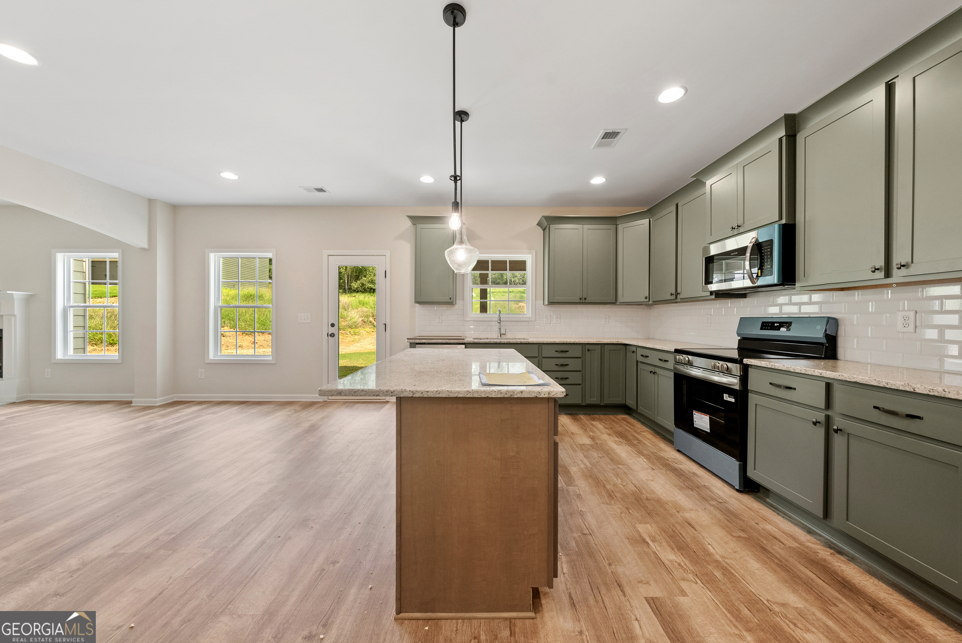 575 Bohannon Road, Unit 8 Grantville, GA 30220 - Photo 8 of 33 a large kitchen with stainless steel appliances granite countertop a stove a sink dishwasher and a refrigerator with wooden floor