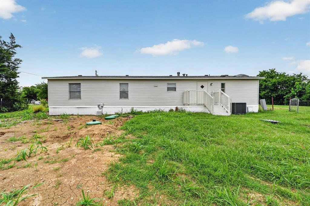 13405 Wheat Road Venus, TX 76084 - Photo 29 of 32 Expansive exterior featuring light-colored horizontal siding, a white entry staircase with railings, and a full-length black roofline