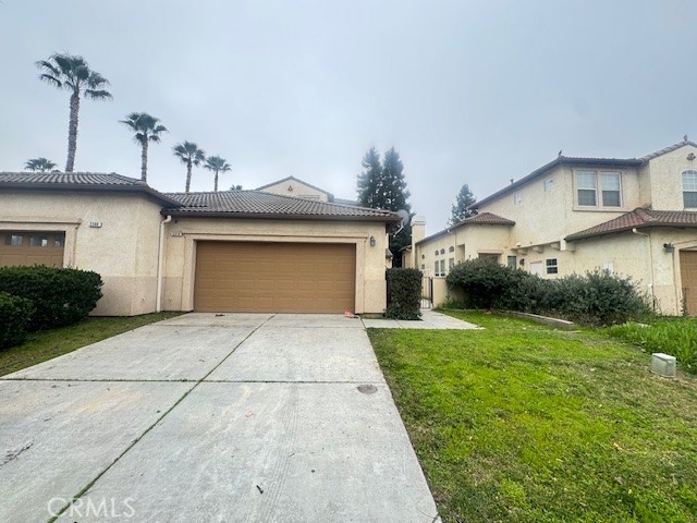 a front view of a house with a garden and plants