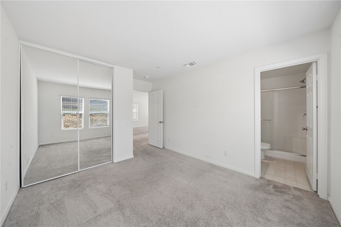 20130 Curaco Court Riverside, CA 92507 - Photo 19 of 43 Bedroom with mirrored closet doors and an attached bathroom.