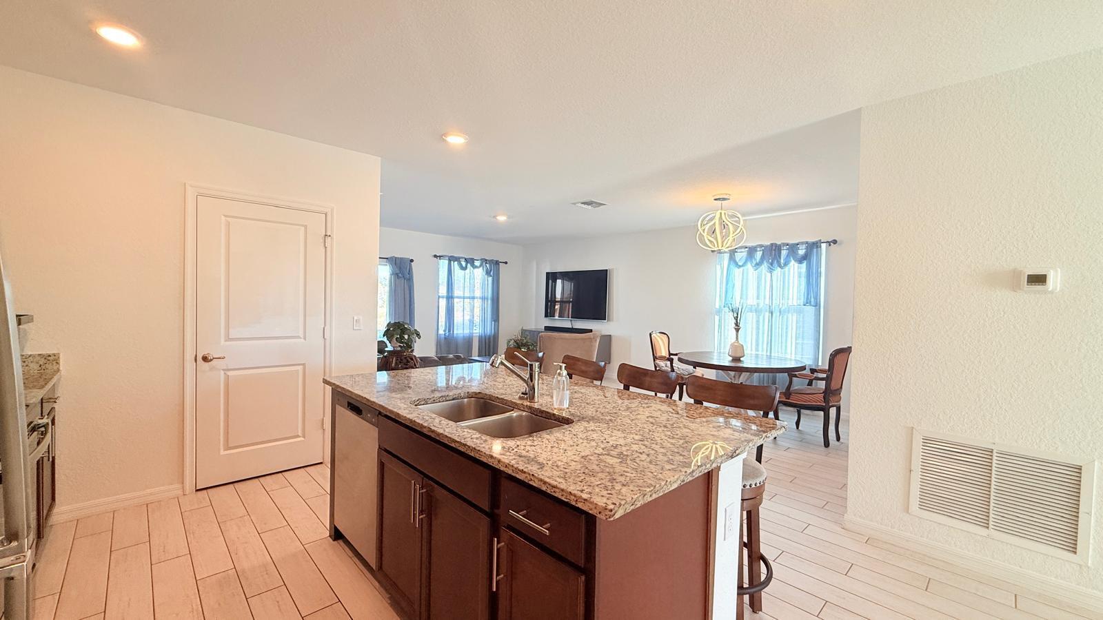 5154 Armina Place Fort Pierce, FL 34951 - Photo 21 of 38 a kitchen with granite countertop kitchen island stainless steel appliances a sink and living room view