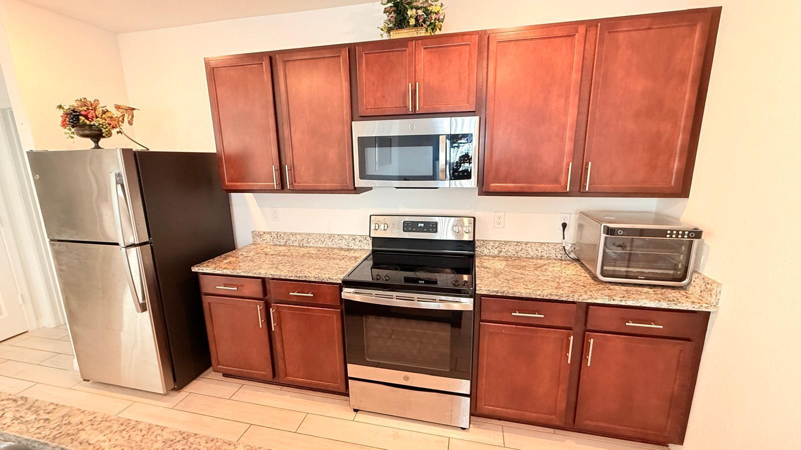 5154 Armina Place Fort Pierce, FL 34951 - Photo 29 of 38 a kitchen with granite countertop a refrigerator stove and microwave