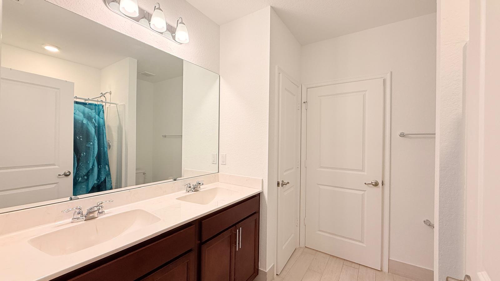 5154 Armina Place Fort Pierce, FL 34951 - Photo 32 of 38 a bathroom with a double vanity sink a mirror and a shower