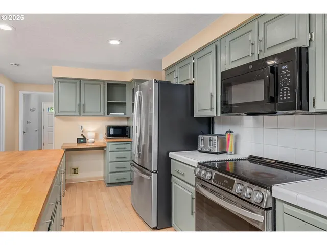 a kitchen with stainless steel appliances a stove microwave and refrigerator