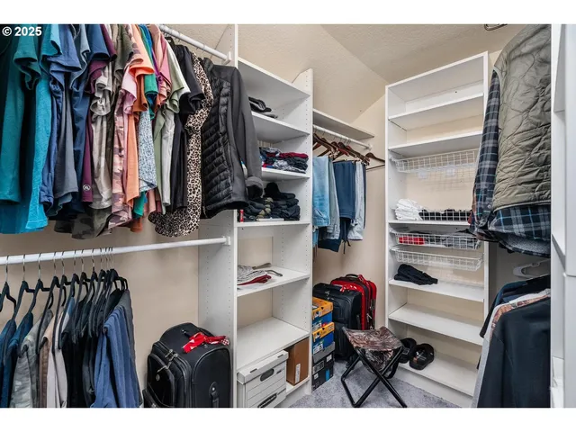 a view of walk in closet with clothes and shoes