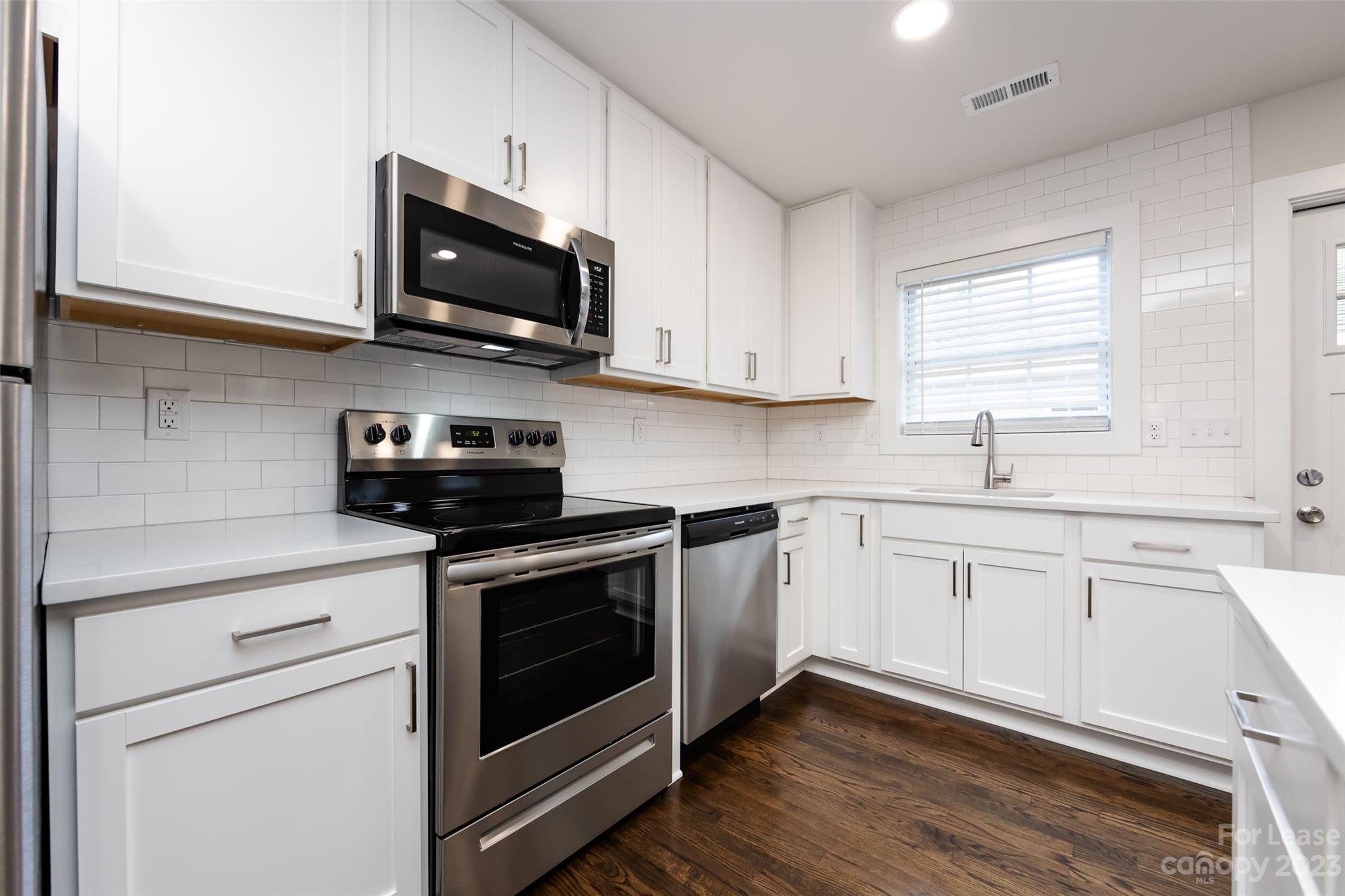 1704 Club Road, Unit A Charlotte, NC 28205 - Photo 16 of 35 a kitchen with stainless steel appliances granite countertop a sink a stove a microwave and wooden cabinets