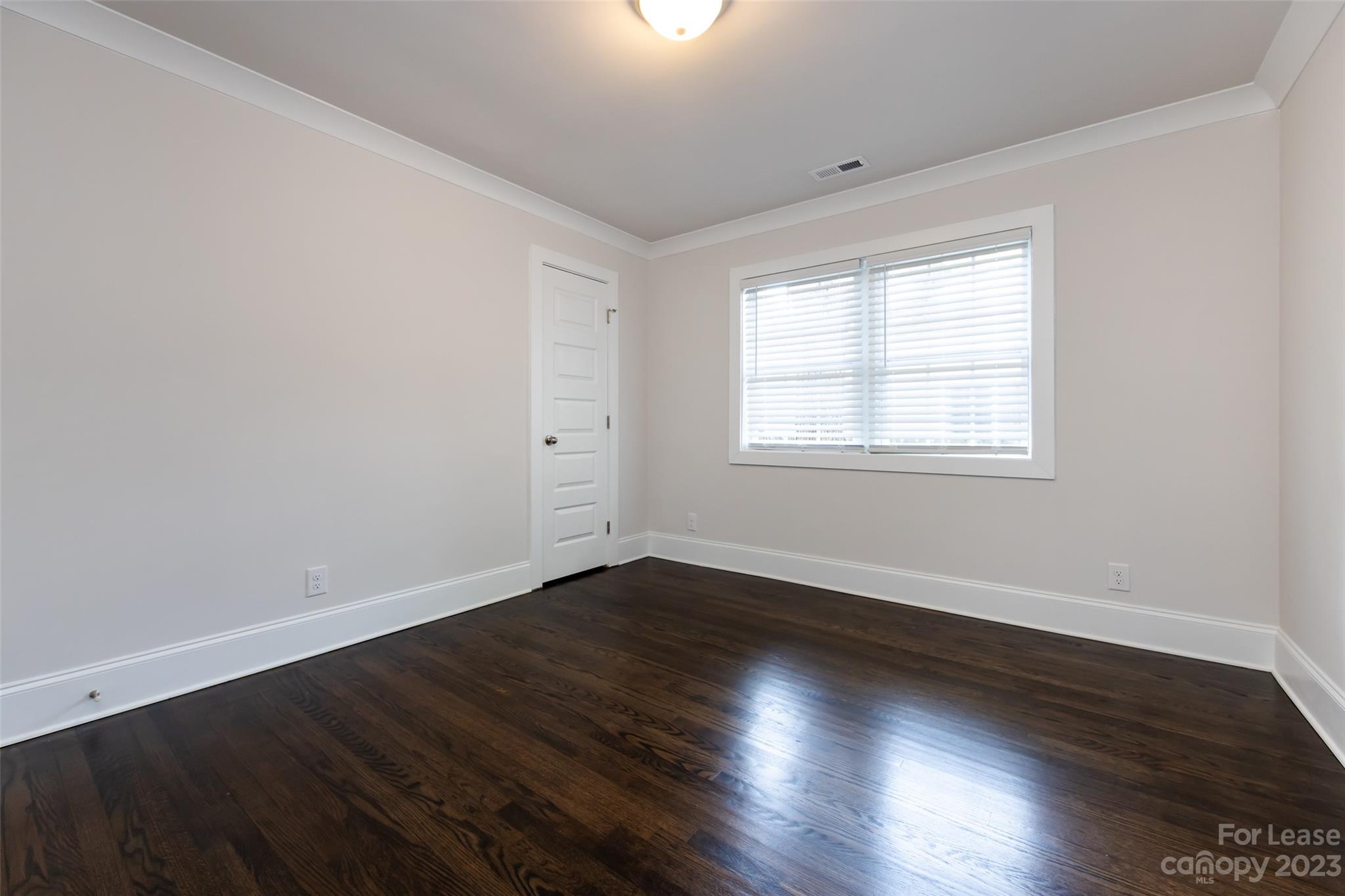 1704 Club Road, Unit A Charlotte, NC 28205 - Photo 22 of 35 an empty room with wooden floor and windows